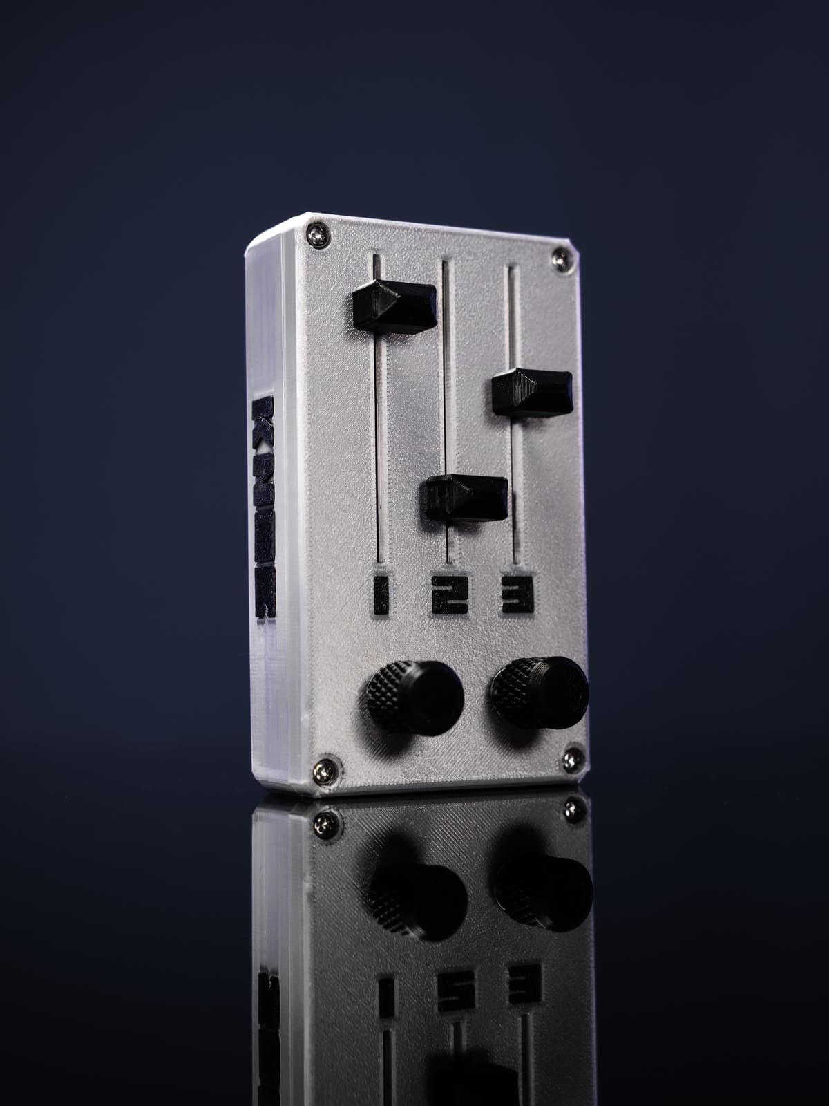 KNOB negro con números y logo blancos, inclinado sobre fondo azul oscuro con reflejo